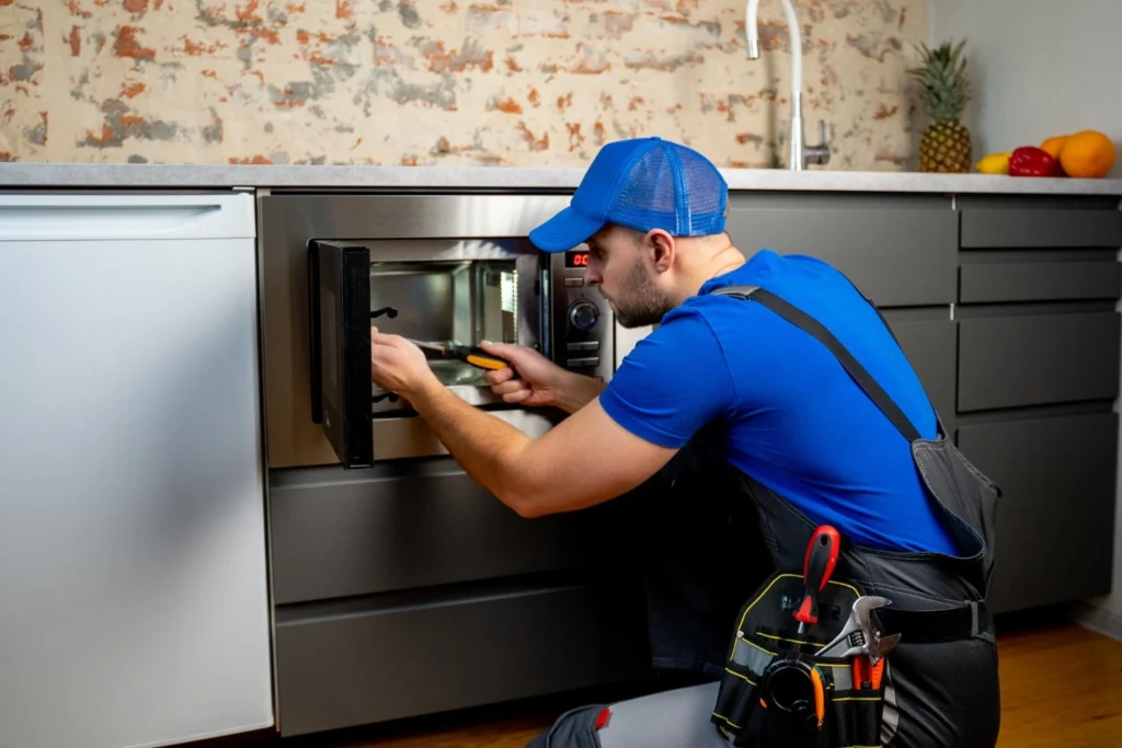 ABS Appliance Repair technician servicing a Wolf range in a Los Angeles luxury kitchen